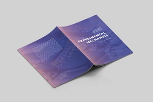 Nufotografuota atversta knyga padėta ant stalo viršeliu į viršų. Knygos pavadinimas "Experimental Mechanics"